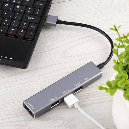 Aluminum Alloy USB 3.0 Hub with Four Ports and LED Indicator connected to laptop showing four USB ports and LED in aluminum body
