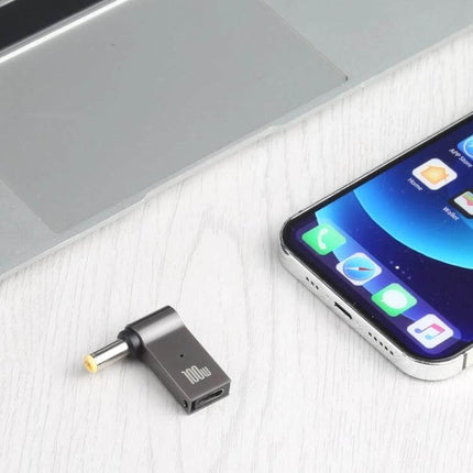 Portable 100W USB-C to DC 5.5mm Adapter for Laptop Charging shown beside laptop and smartphone, compact 100W USB-C to DC charging adapter