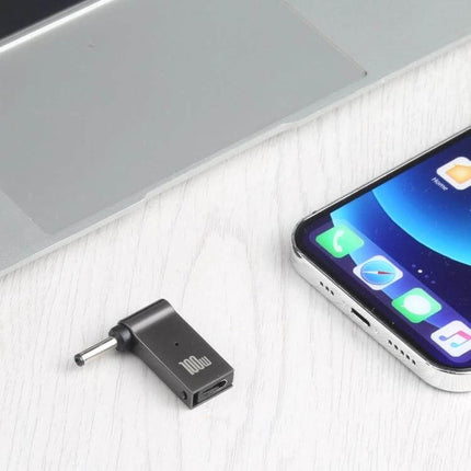 Compact USB-C to DC Adapter for Laptop Charging - compact black adapter beside phone and laptop for travel charging