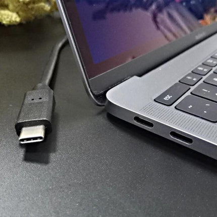USB Cable for Daily Device Charging at Home or Work — USB-C cable next to laptop for everyday charging at desk or on the go