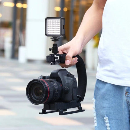 PULUZ C-Shaped Handheld Camera Stabilizer with LED Light Kit held by hand with DSLR and mounted LED for steady vlogging