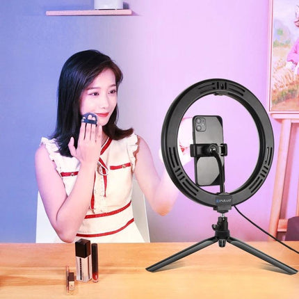 PULUZ LED Ring Light for Vlogging and Photography illuminating female vlogger applying makeup with phone mounted on tripod