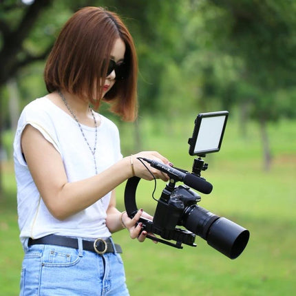 PULUZ C-Shaped Handheld Camera Stabilizer for Video Recording held by a videographer for smooth outdoor footage