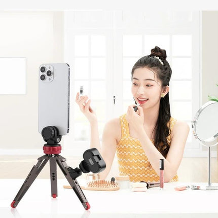 PULUZ Tripod Ball Head Adapter with Knob for Camera Adjustment mounted on tabletop tripod holding smartphone while woman applies makeup