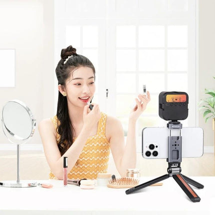 PULUZ Aluminum Alloy Phone Clamp Holder with Cold Shoe Mount securing smartphone on tabletop tripod with LED light for makeup tutorial