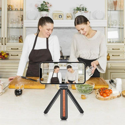 PULUZ Aluminum Alloy Phone Clamp Holder with Cold Shoe Mount securing smartphone on tabletop tripod for cooking tutorial with lights and mic attached