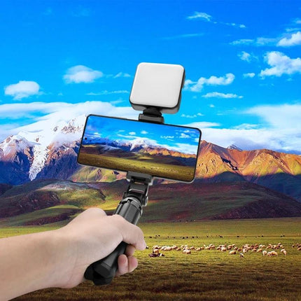 PULUZ Z-axis Phone Clamp with 360 Rotation for Versatile Mounting shown holding smartphone and LED light on a tripod for stable outdoor vlogging