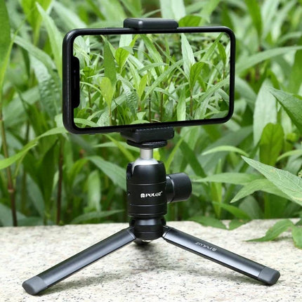 PULUZ Compact Metal Desktop Tripod for Travel Photography with smartphone mounted on mini tripod in outdoor grass setting