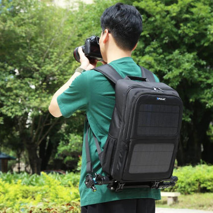 PULUZ Solar Powered Backpack for Outdoor Camera and Laptop Use worn by photographer in park, solar panels visible, camera gear and tripod attached