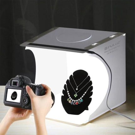 PULUZ Portable 20cm Folding Light Box for Product Photography showing camera shooting a necklace in a compact illuminated studio