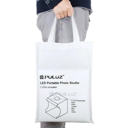 PULUZ Portable Folding Light Box for Small Item Photography carrying bag held by person showcasing portable photo studio kit