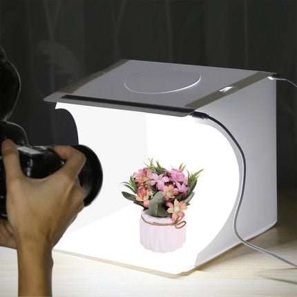 PULUZ Portable Folding Light Box for Small Item Photography capturing a floral arrangement with camera in controlled white backdrop