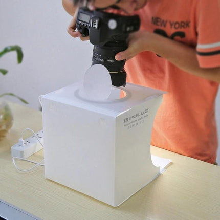 PULUZ Portable Ring LED Light Box for Small Item Photography showing a camera shooting a small product inside the illuminated white cube