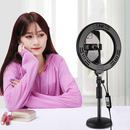 PULUZ LED Ring Light for Everyday Video and Photo Use showing model at desk with compact ring light on stand improving skin tones and reducing shadows
