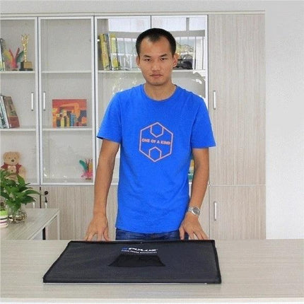 PULUZ Portable Photo Studio Light Box, 60 cm Cube on table with man demonstrating compact foldable setup for product photography