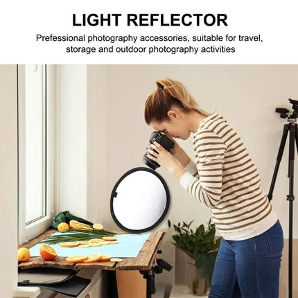 PULUZ 30cm Folding Reflector with Silver and Gold Surfaces for Photography used by photographer to add warm gold or bright silver light to tabletop portrait shots