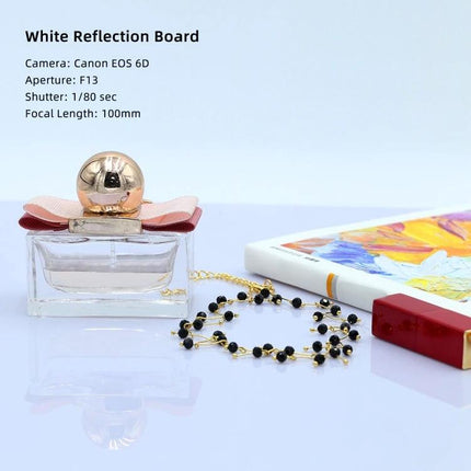 PULUZ 29cm Acrylic Reflective Photography Display Board showing perfume bottle, necklace and lipstick with clear reflections on black acrylic surface
