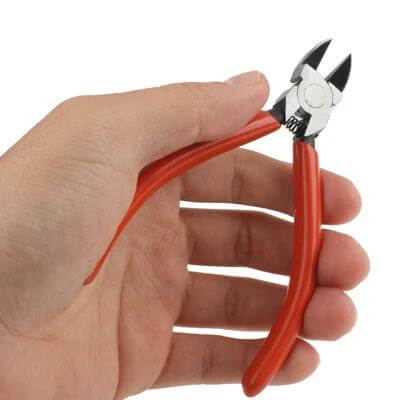 Plastic Nippers 125mm For Precise PCB Work, General Electronics - red-handled flat-blade nippers held in hand for trimming wires and PCB leads