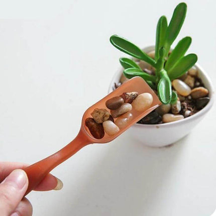 Plastic Soil Shovel Spoon For Transplanting Seedlings - orange plastic scoop placing pebbles and soil beside a small potted succulent