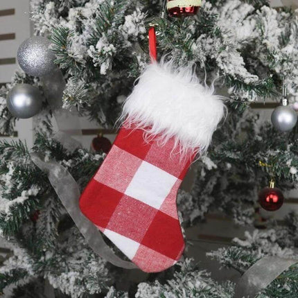 Plush Christmas Sock Gift Bag Ornament For Holiday Decor Red And White - red plaid plush stocking with white faux fur cuff hanging on snowy Christmas tree