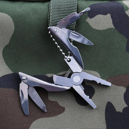 Portable Multifunction Folding Plier Keychain For Everyday Carry stainless steel multi-tool with pliers screwdriver and knife on camo background