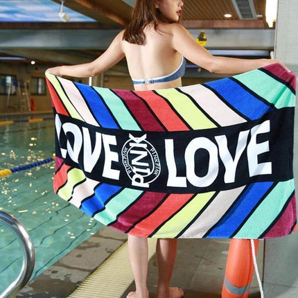 Printed Soft Bath Towel 147x71 cm For Home And Beach - colorful striped beach towel with LOVE print held by woman at indoor pool