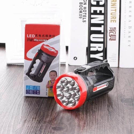 Rechargeable Outdoor LED Flashlight With Two Modes displayed on wooden table with packaging and multiple LED bulbs, portable handle and red bezel