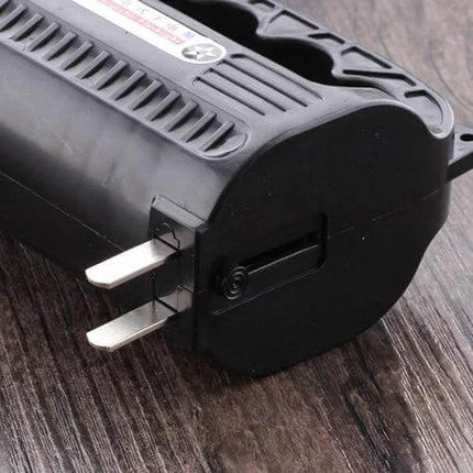 Rechargeable Outdoor LED Flashlight With Two Modes showing built-in folding plug and textured grip on wooden surface