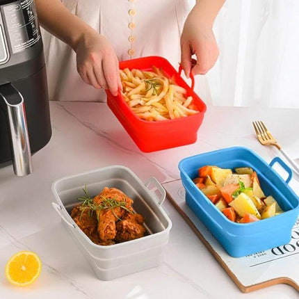 Rectangular Foldable Silicone Air Fryer Basket with fries in red silicone liner next to gray and blue liners holding chicken and vegetables