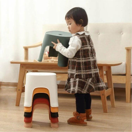 Row Stool for Bathroom and Living Use, Adult and Child Sizes - compact stackable PVC step stool shown with child lifting a green stool next to stacked stools