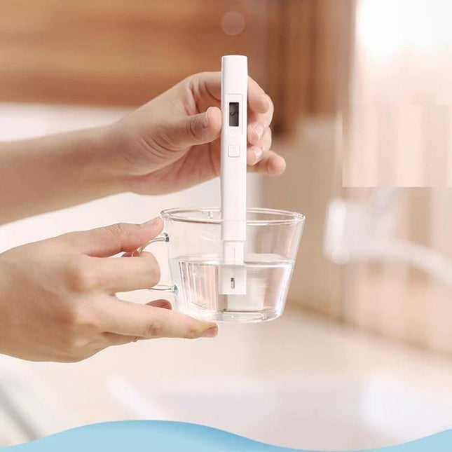 Xiaomi Compact Water Quality Tester for Everyday Home Use - hand holding tester measuring TDS in a glass of water