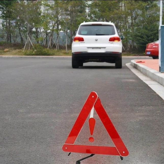 Foldable Reflective Safety Triangle for Roadside Warnings placed on pavement in front of stopped white car to alert approaching drivers