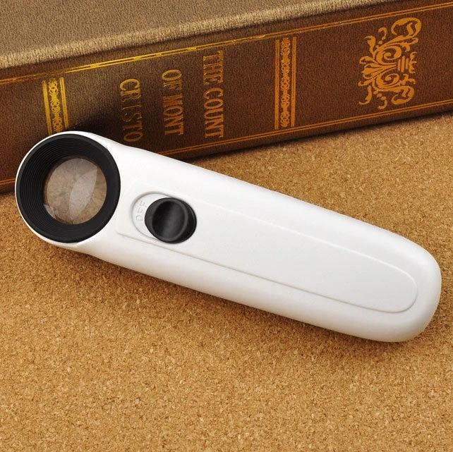 Handheld 40X Magnifier with LED Light for Everyday Reading — white handheld loupe with integrated LED beside book, ideal for reading fine print