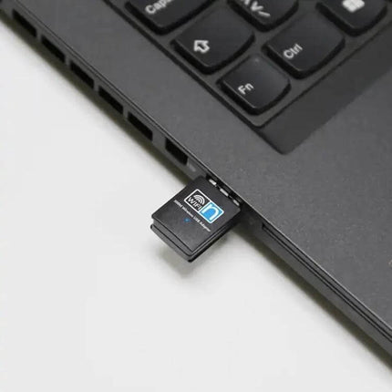 Wireless USB Adapter for Portable Internet Connectivity plugged into a laptop USB port showing compact design for travelers and remote workers