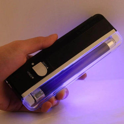 Handheld Security Feature Verifier for Banknotes And Passports illuminating banknote under UV light for watermark and strip inspection