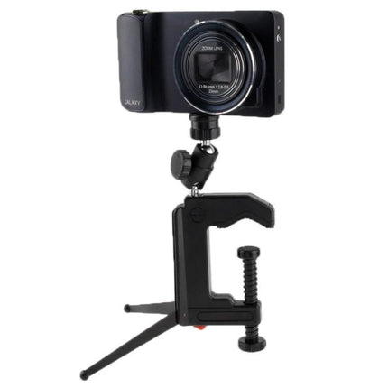 Portable Folding Clamp Tripod for Mini Digital Cameras with compact clamp, 1/4-inch socket and rubber padding holding a mini digital camera