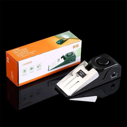 Portable Wedge Door Stop Alarm for Home and Travel Security showing black wedge alarm with key and packaging on black background
