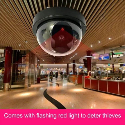 Realistic Fake Security Camera with Motion Detection for Home Protection - dome-style deterrent with flashing red light mounted in shopping center