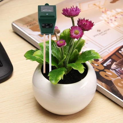 3-in-1 Soil Meter for Measuring pH, Moisture, and Light in Plants inserted into potted flowering plant to check soil pH, moisture and light