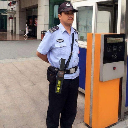 Security guard using Hand-Held Metal Detector for Security Screening and Crowd Control to scan visitors at an entrance