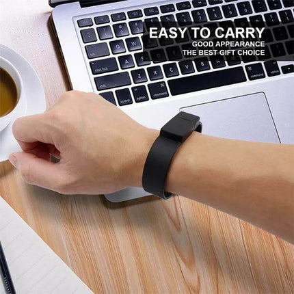 Green 16GB Silicon Bracelet USB Drive for Data Storage worn as a wrist bracelet next to laptop for portable file transfers