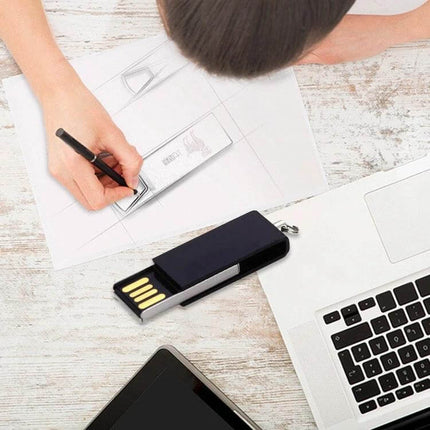 Mini Rotatable USB Flash Drive for Everyday Data Storage on desk next to laptop and tablet