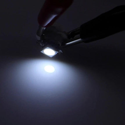 B8.5 12V LED Instrument Panel Light Bulb For Vehicle Dashboard lit white LED held by pliers showing bright beam for gauge illumination
