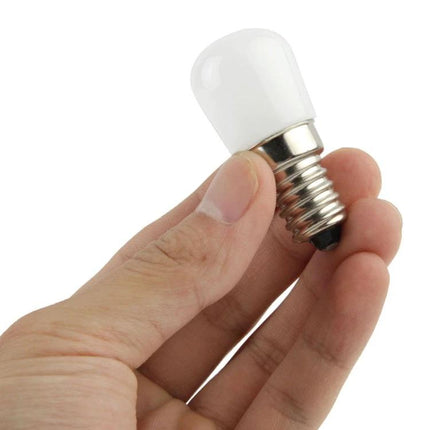 Compact Warm White LED Bulb for Everyday Home Lighting held between fingers, compact size for bedside lamps and sconces