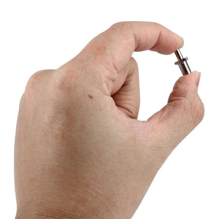 RP-SMA to TS9 Adapter for Wireless Antenna Connections held between fingers, showing compact metal connector for routers and hotspots