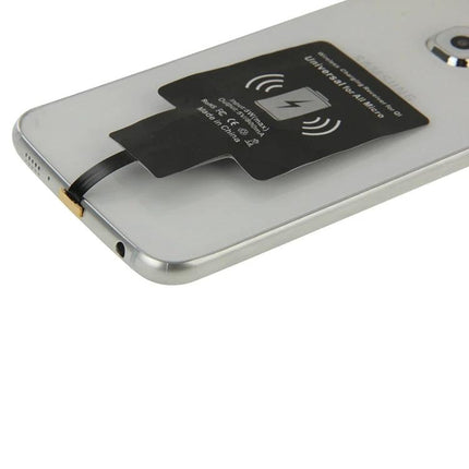 Essential Receiver for Everyday Micro USB Phone Charging shown attached to a smartphone back enabling Qi wireless charging on a nightstand or desk