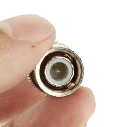 BNC Plug Terminator for Effective Signal Termination in Cables - metal BNC termination held between fingers for CCTV and AV cable signal stability