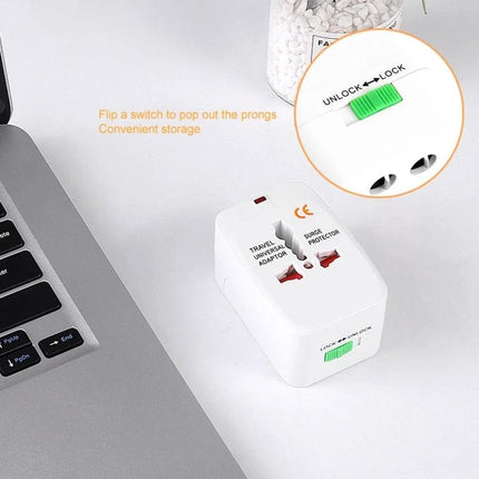 Universal Travel Adaptor for Worldwide Electrical Outlets compact white adaptor with lock switch next to laptop for charging smartphones and laptops