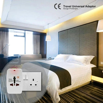 Universal Travel Adaptor for Worldwide Electrical Outlets shown in hotel room near bed, compact multi-country plug for charging phones and laptops