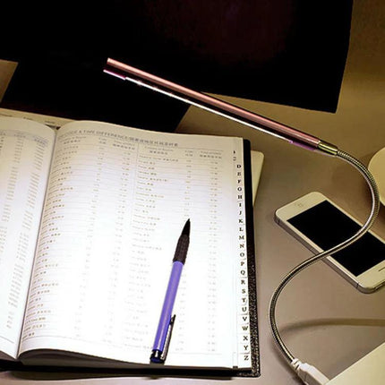 Flexible USB Light for Travel and Laptop Use illuminating open notebook on desk with phone and pen, flexible gooseneck focused reading light